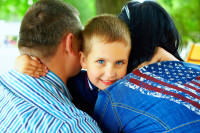 Adoption after infertility: boy hugs parents