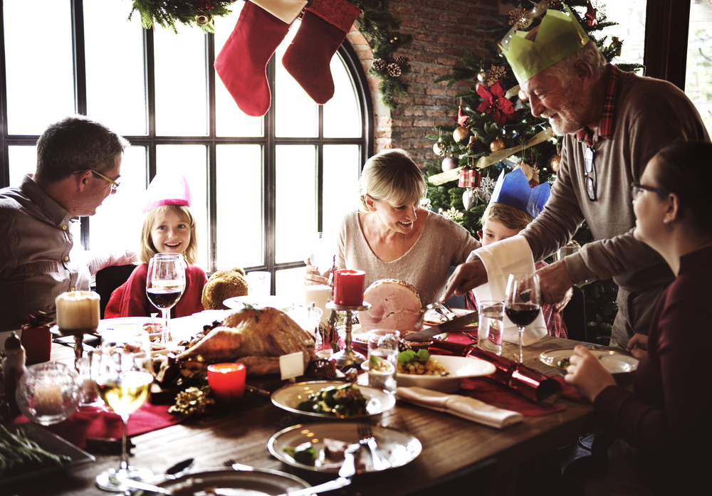 Family sits at a table for christmas