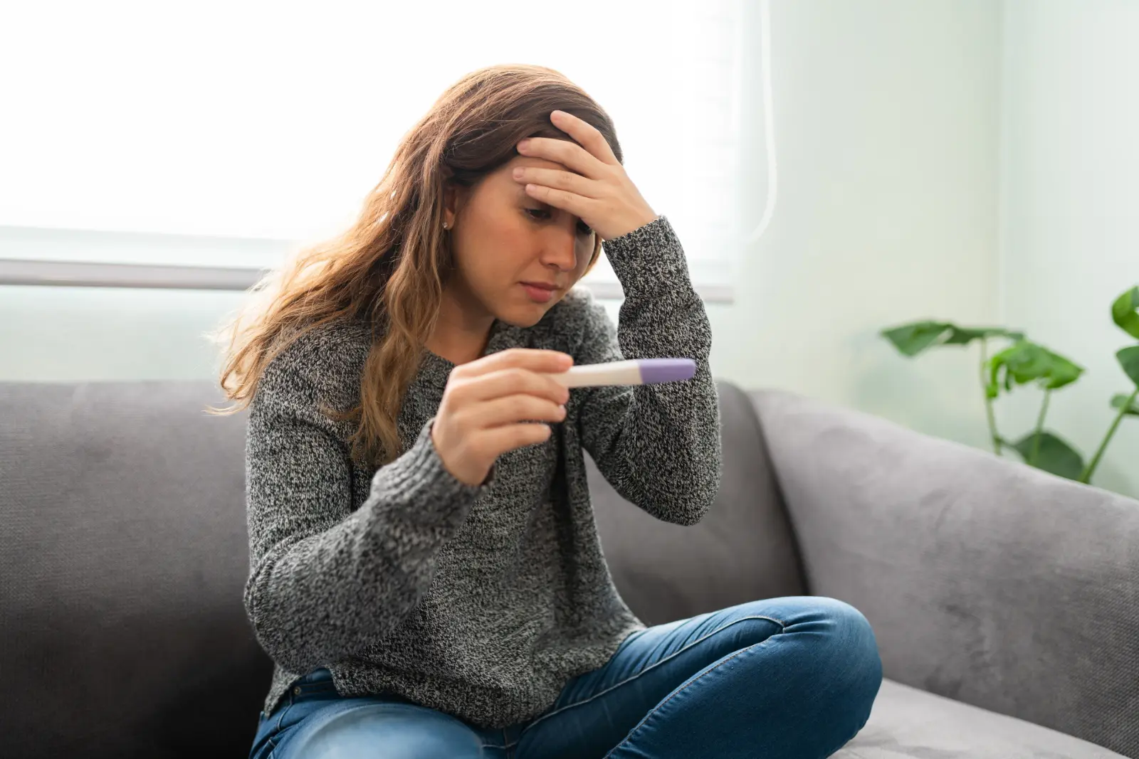 Birth Parent Involvement. stressed woman staring at pregnancy test.