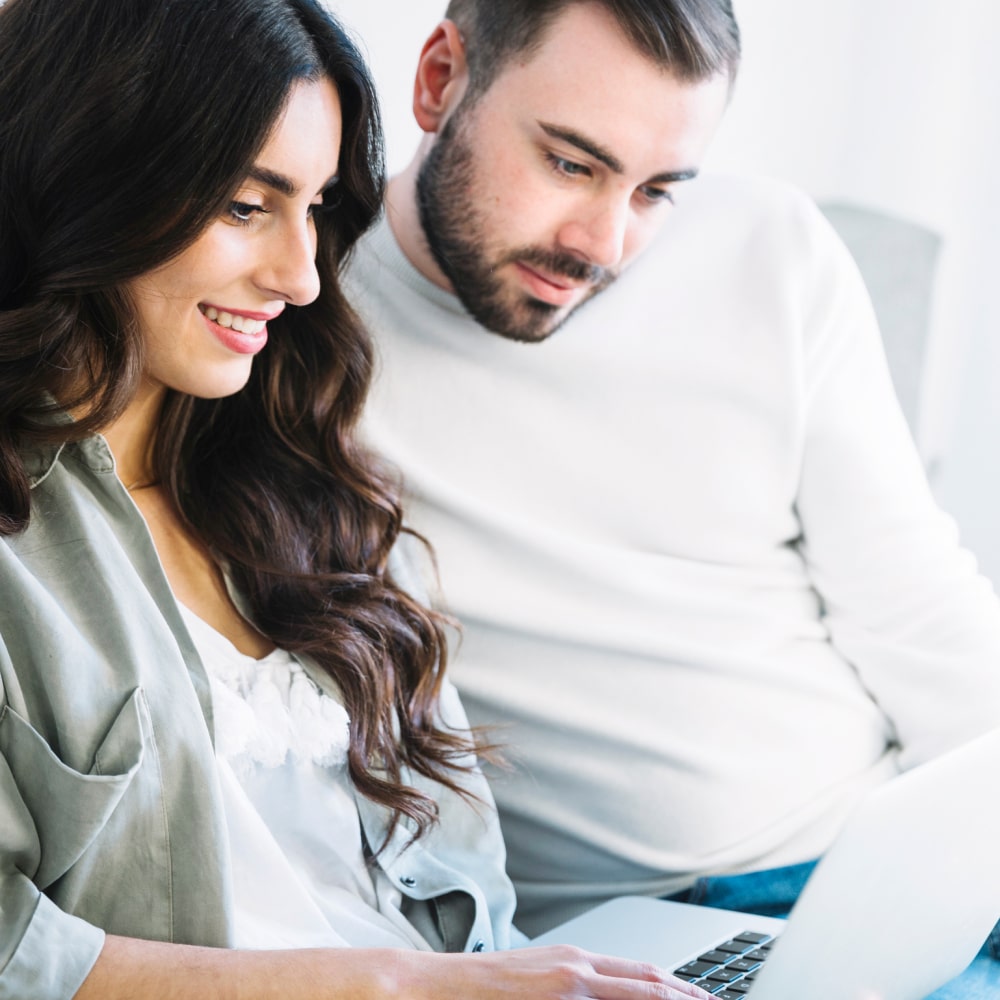 Color image in a circular frame of an infant's hand being held by an adult's hands
