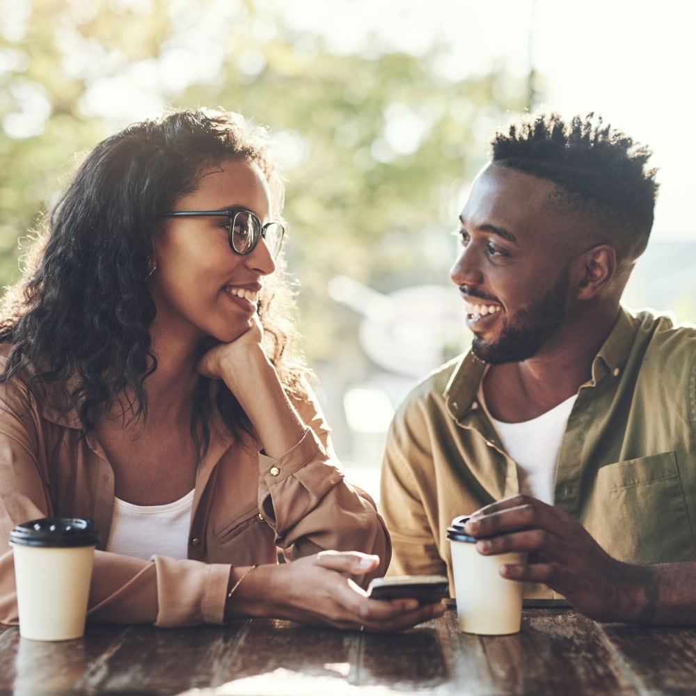 Color image in a circular frame of an infant's hand being held by an adult's hands