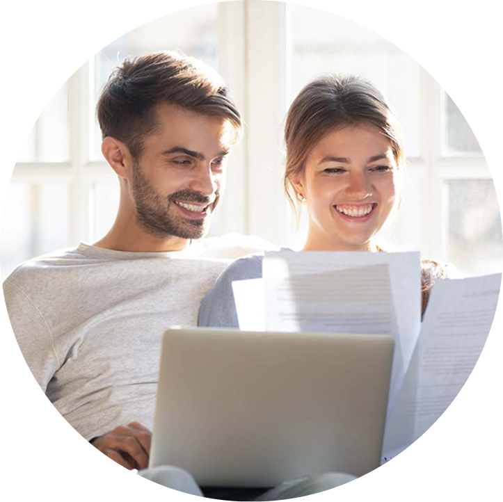 A man and woman sit with a laptop and papers.