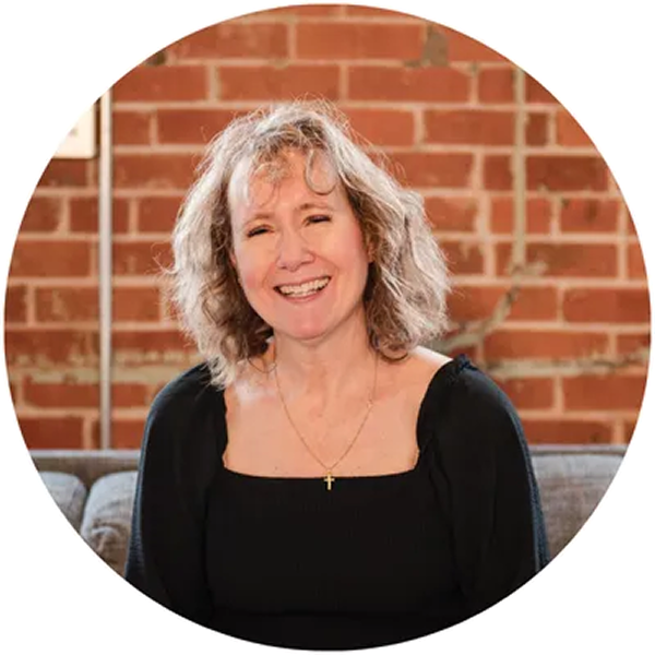 Color image in a circular frame of an infant's hand being held by an adult's hands