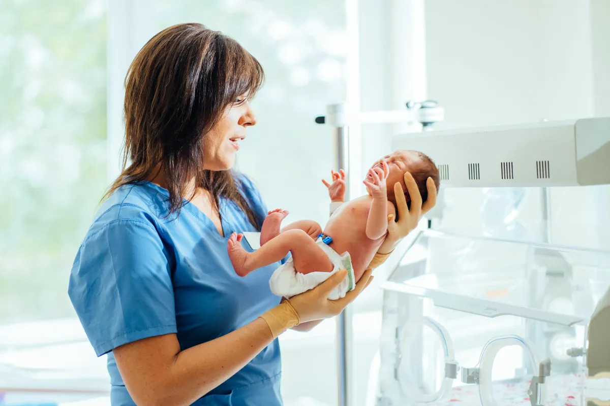 Hospital nurse holding a newborn in the labor and delivery unit