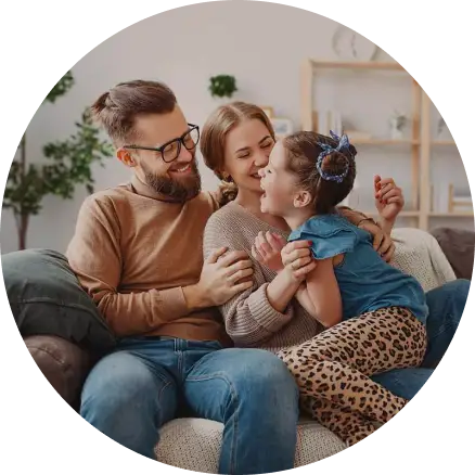Adoptive parents smiling and laughing with their daughter